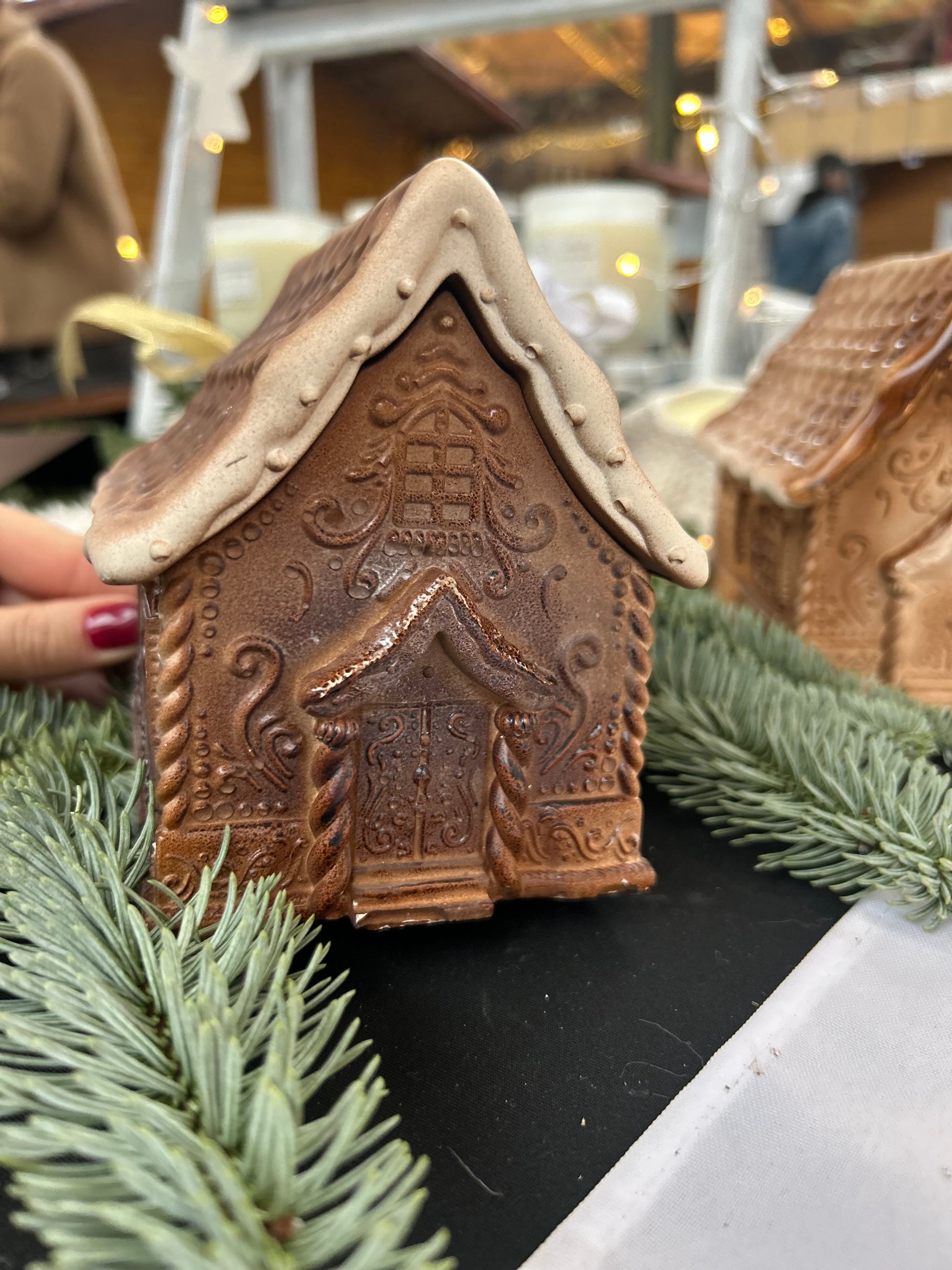 Maison pain d’épices décorative bougie artisanale aux détails sculptés.