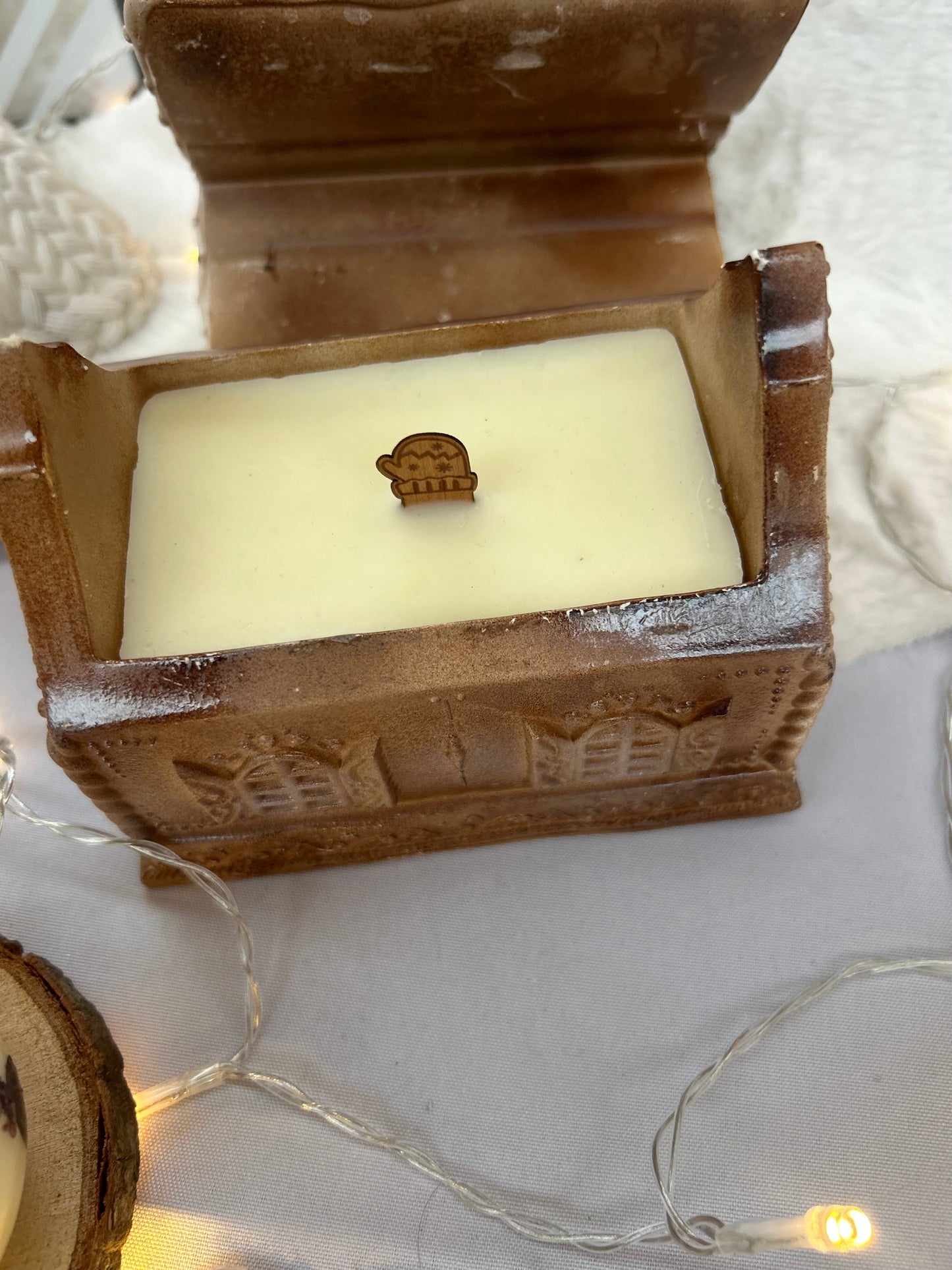 Bougie de Noël en forme de maison pain d’épices, finition artisanale chaleureuse.