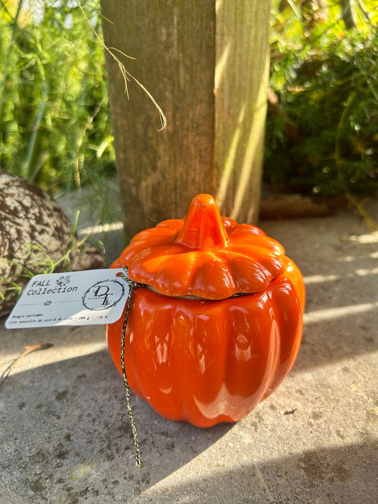Orange ceramic pumpkin with a tag on a stone surface
