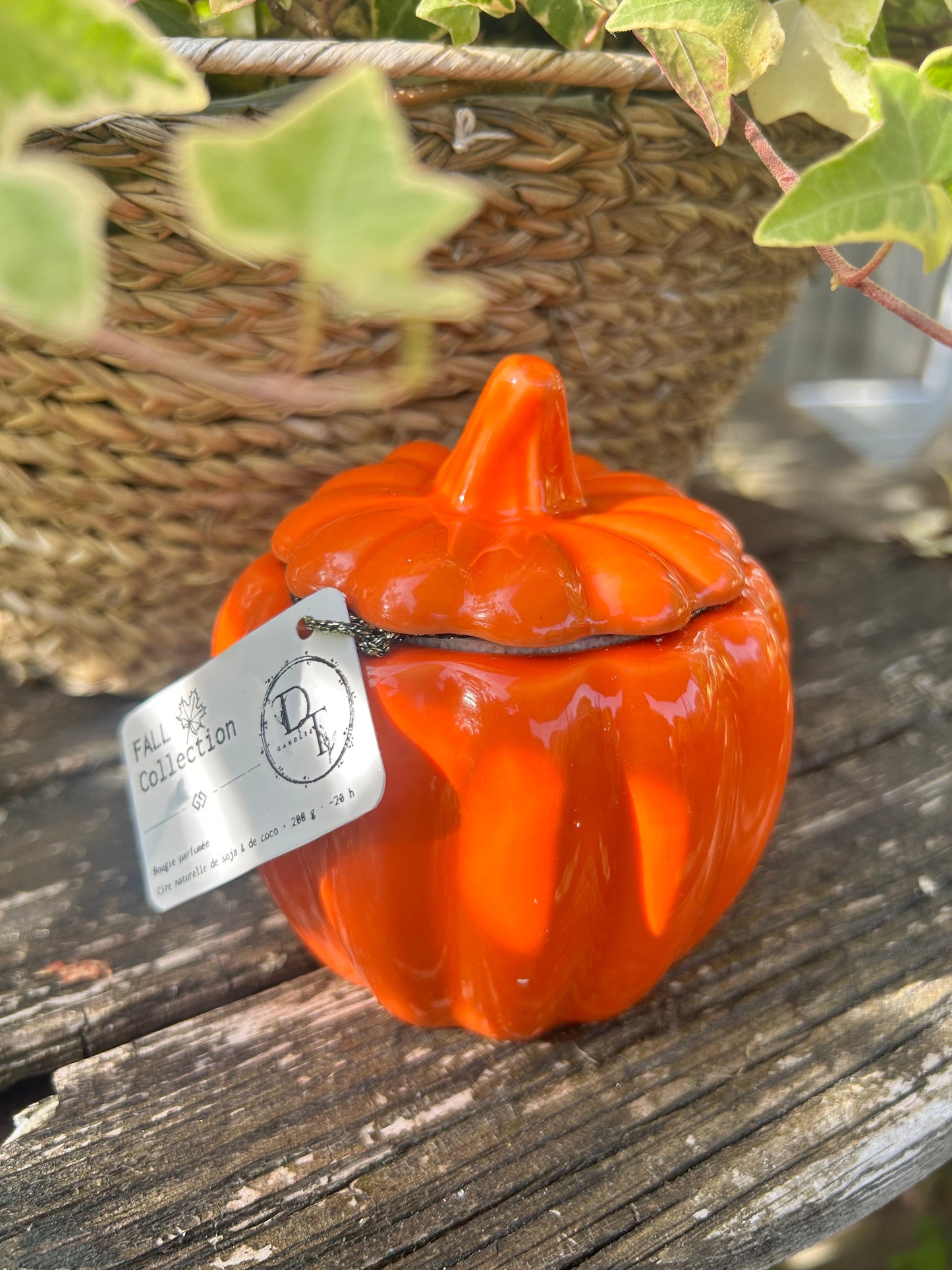 Orange ceramic pumpkin with a tag on a wooden surface