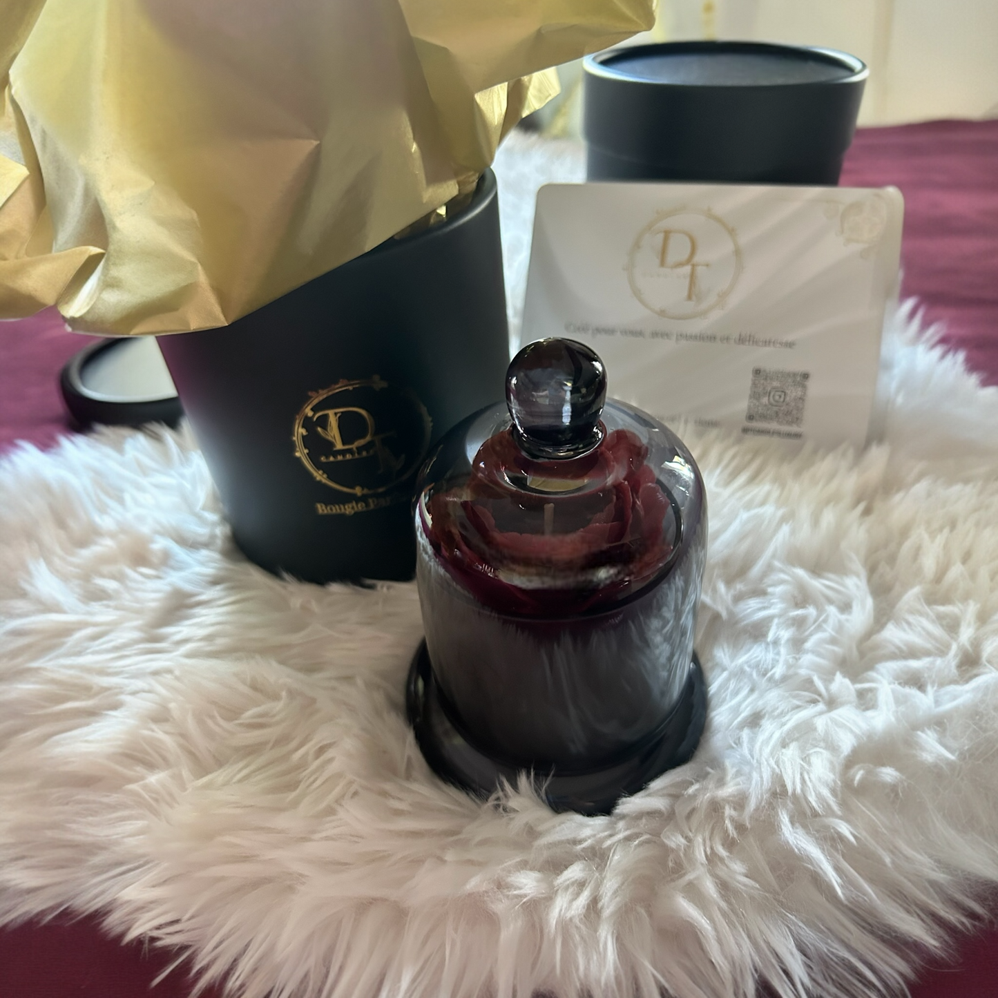 Perfume bottle with packaging on a fluffy white surface