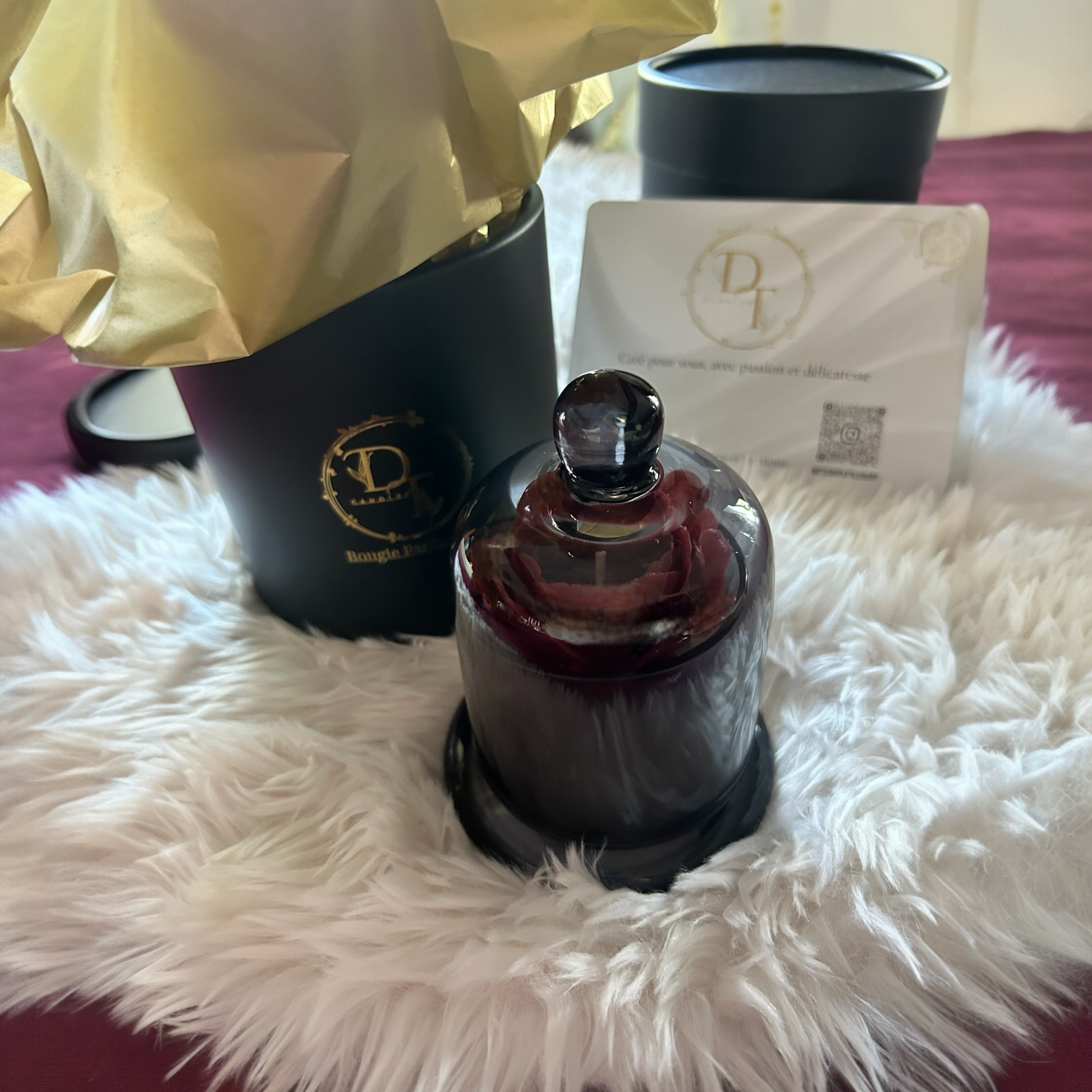 Perfume bottle with packaging on a fluffy white surface