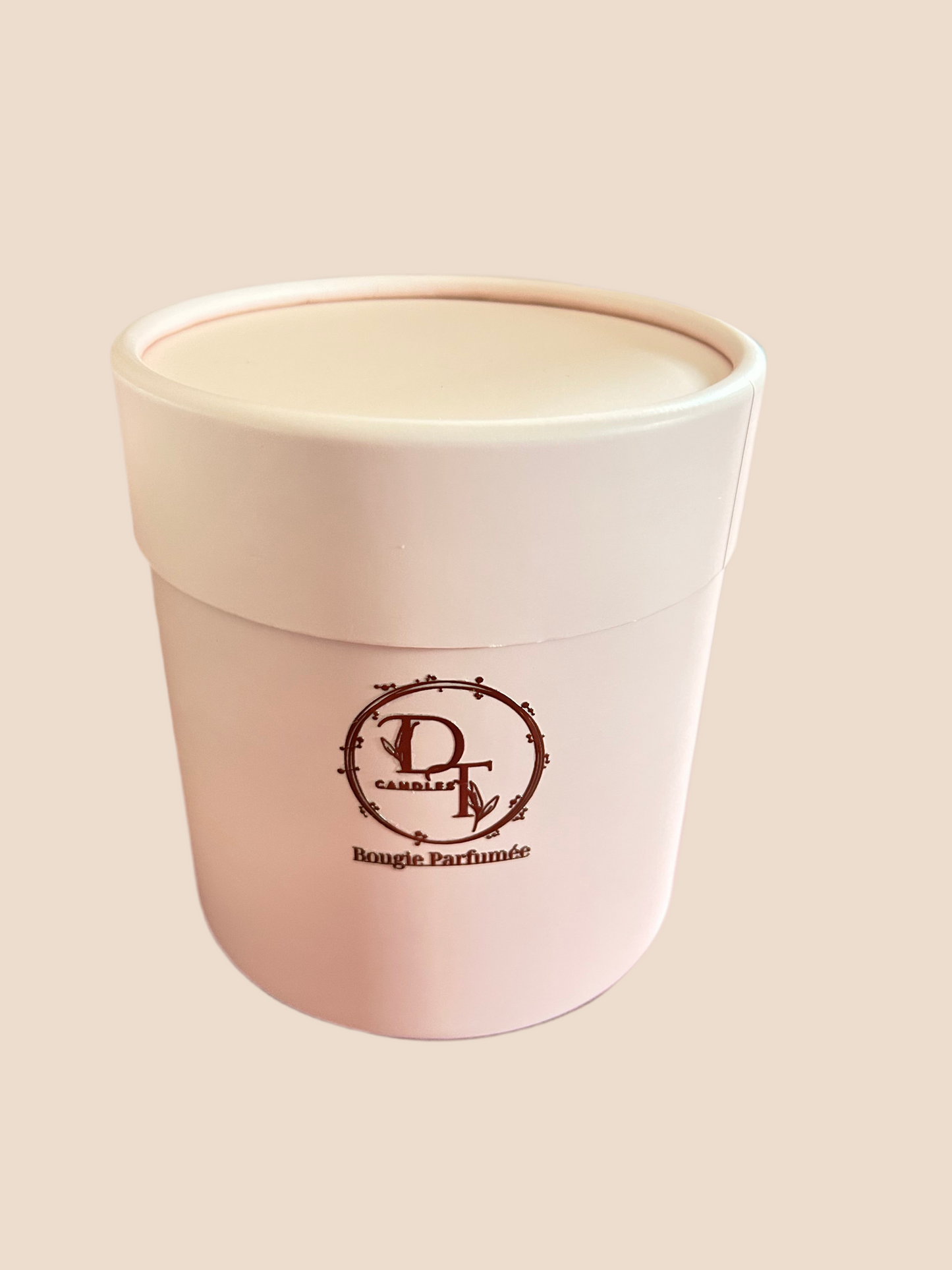 Pink candle container with a logo on a beige background