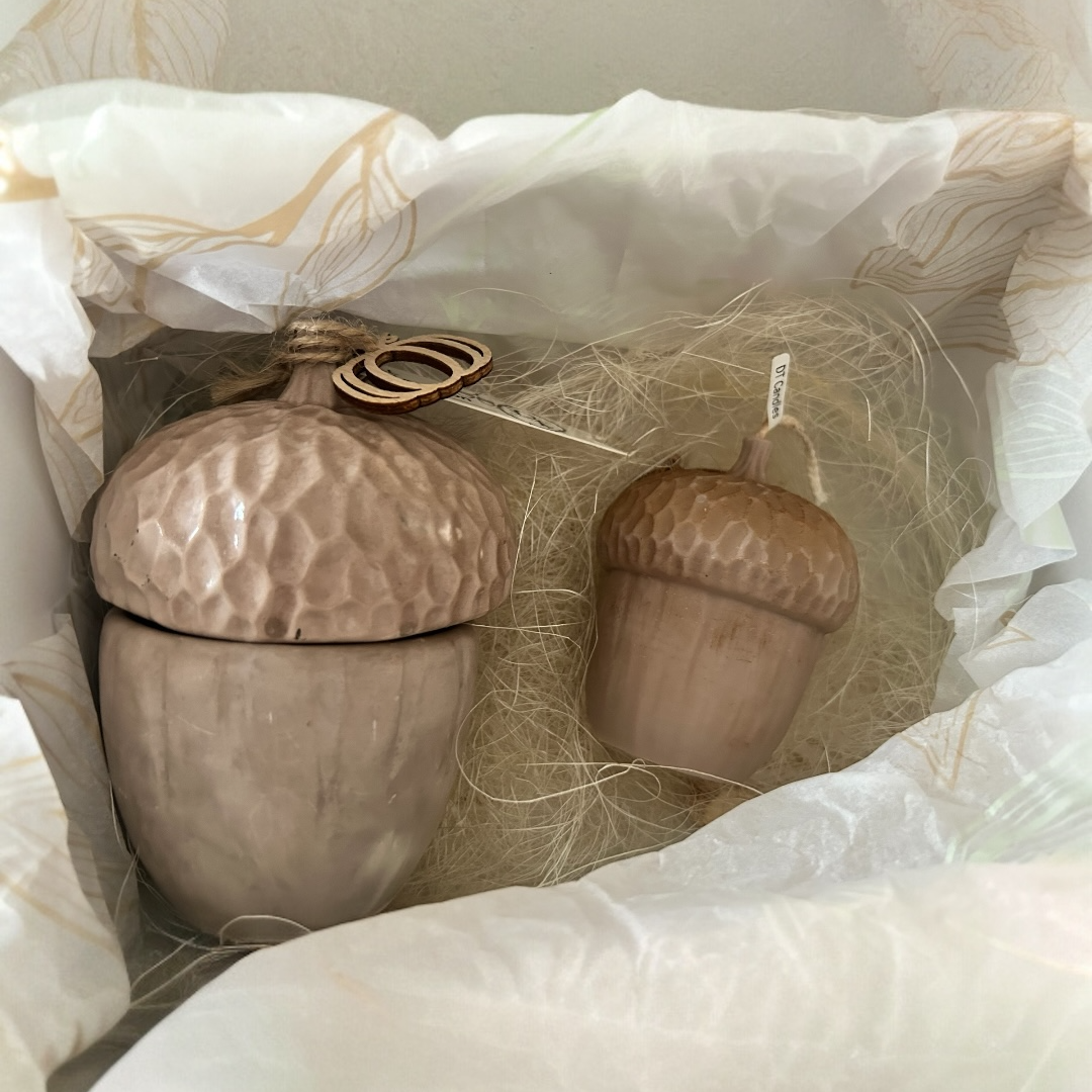 Decorative acorn-shaped container with a smaller acorn on a soft white background