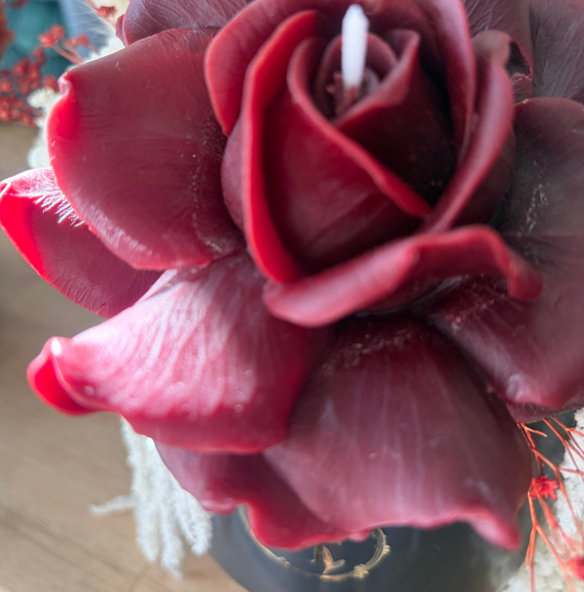 Gros plan d’une rose en cire d’abeille bordeaux sculptée à la main
